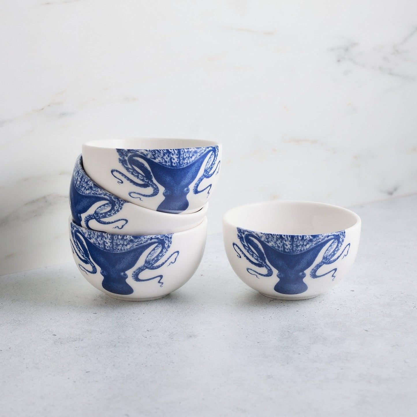 Four matching Lucy blue octopus snack bowls, with three stacked beside one individual bowl