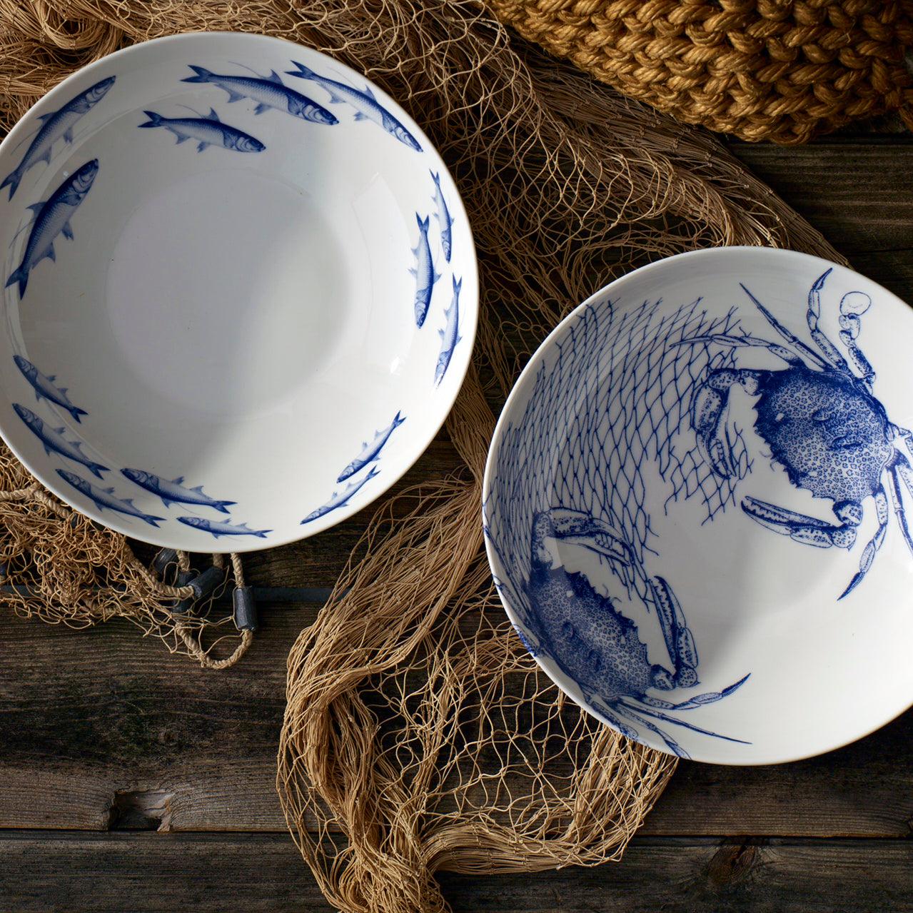 two blue and white plates sitting on top of a wooden table