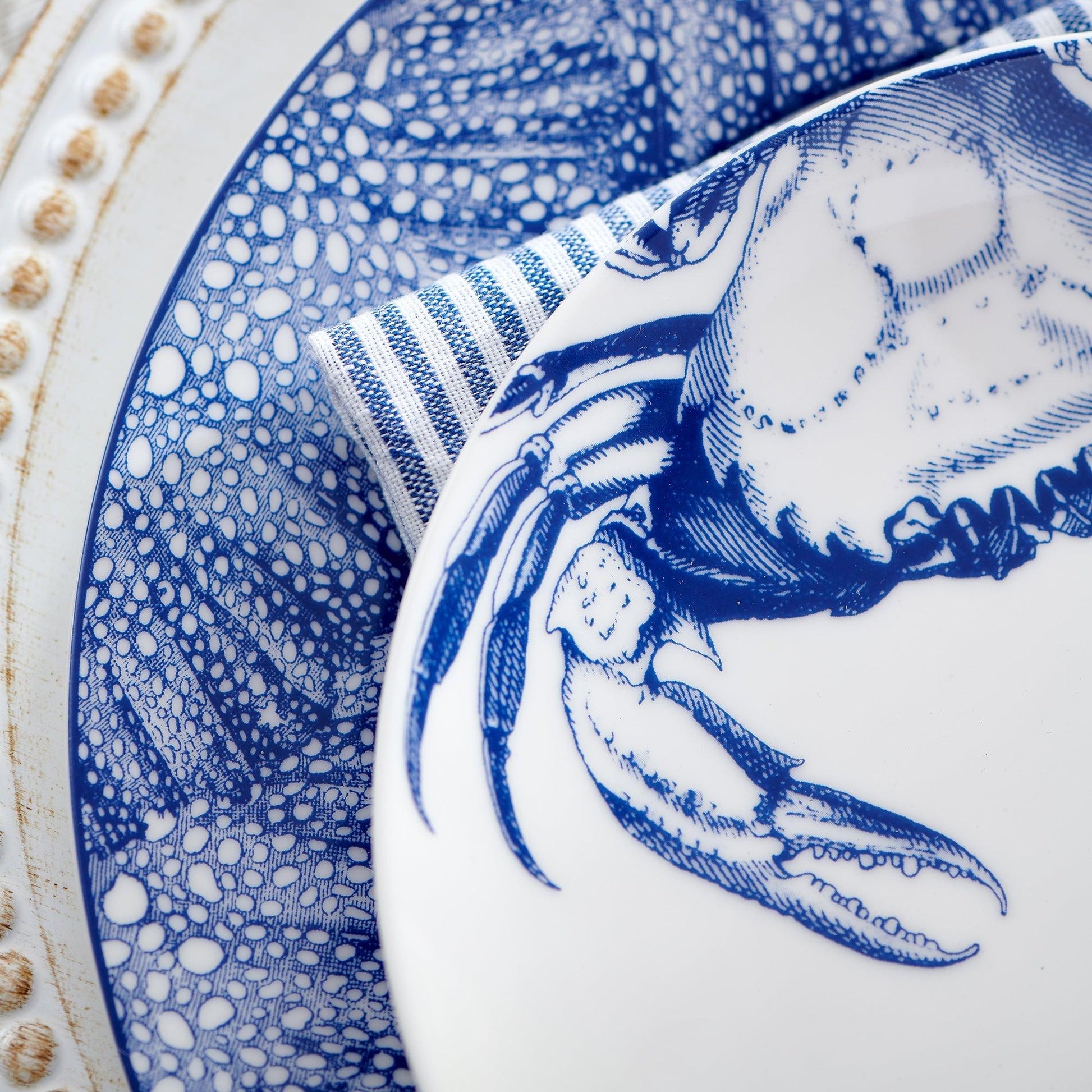 a blue and white plate with a crab on it