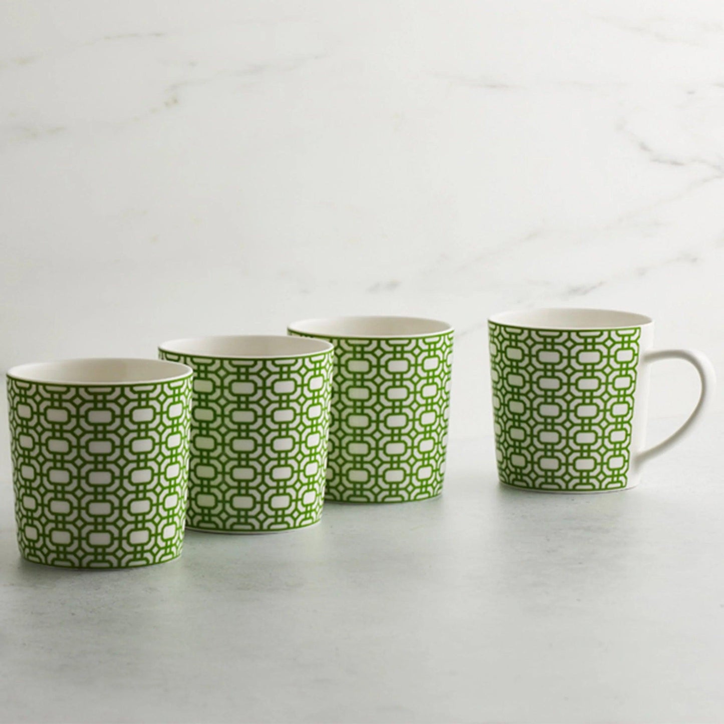 a set of four green and white coffee mugs