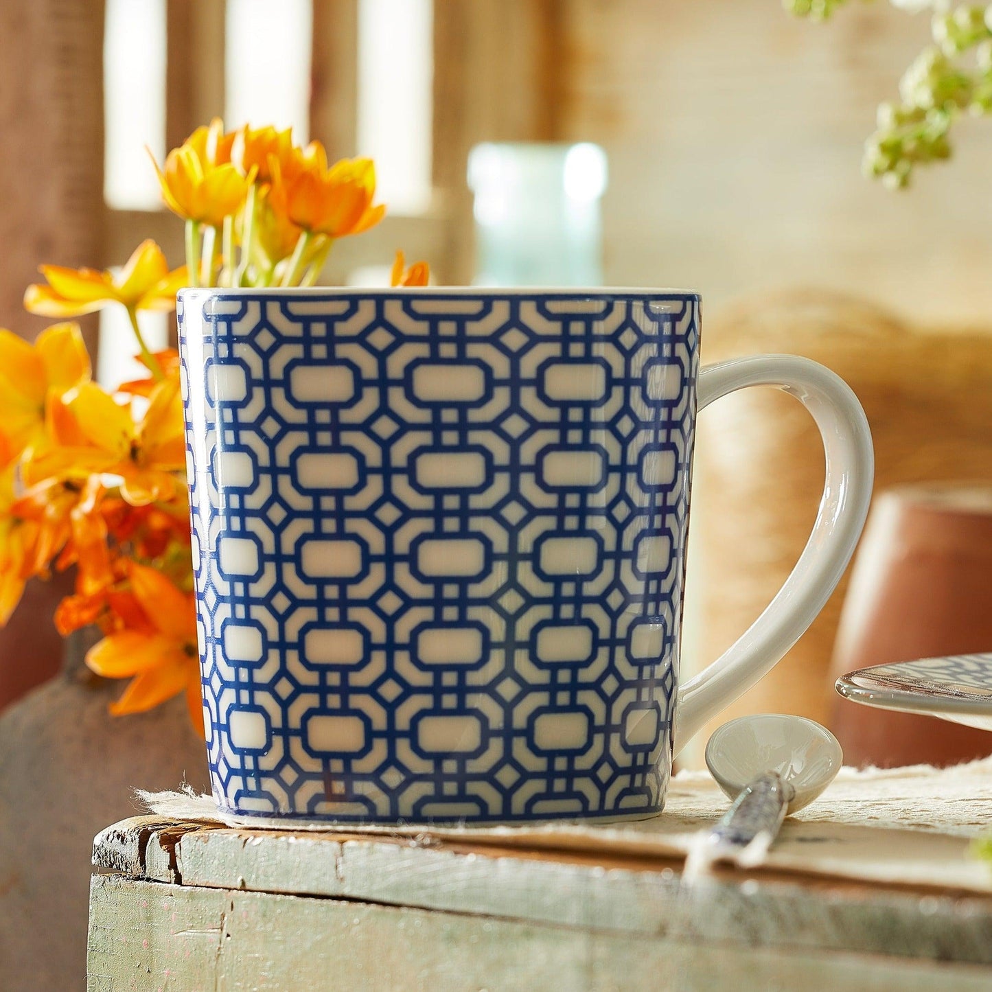 a blue and white coffee cup sitting on top of a table