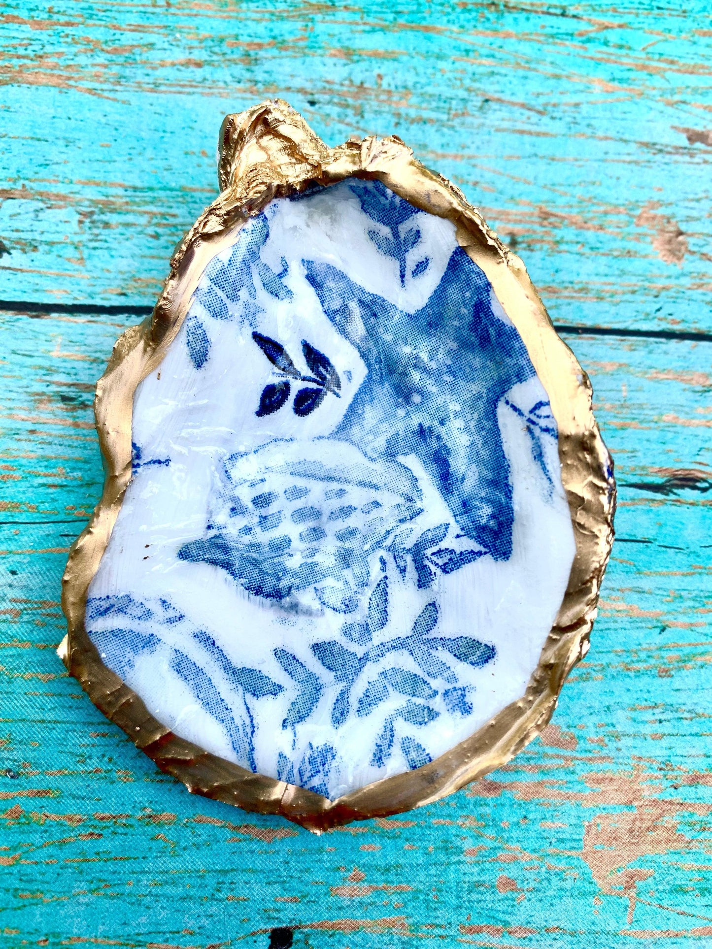 Gold oyster shell with blue and white painted design