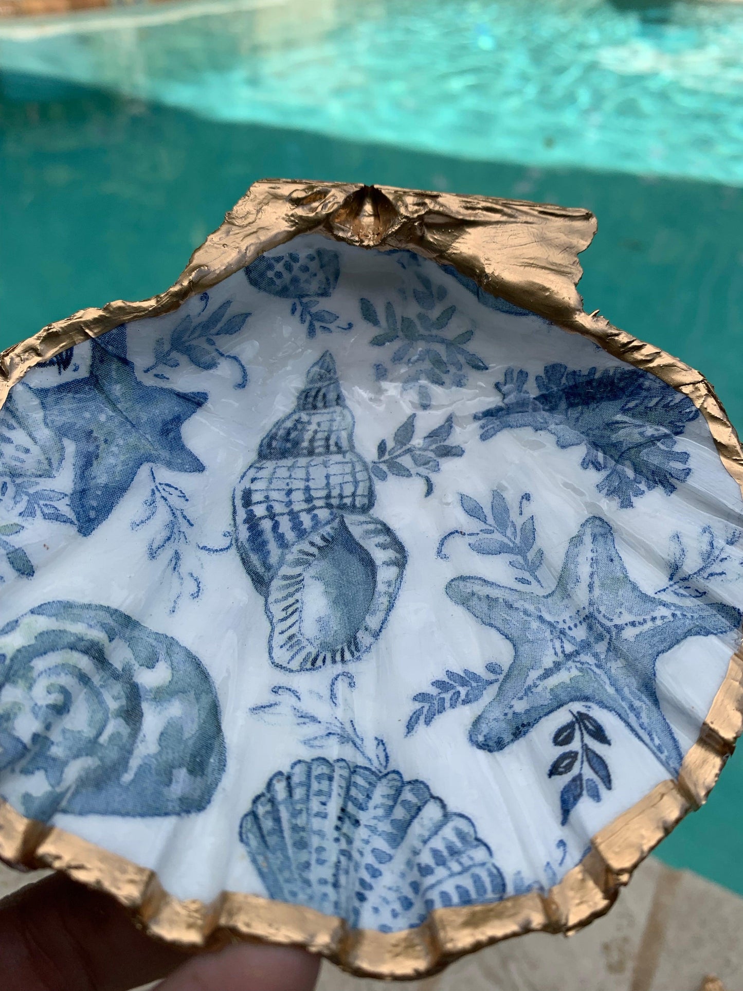 Gold shell with blue and white painted design
