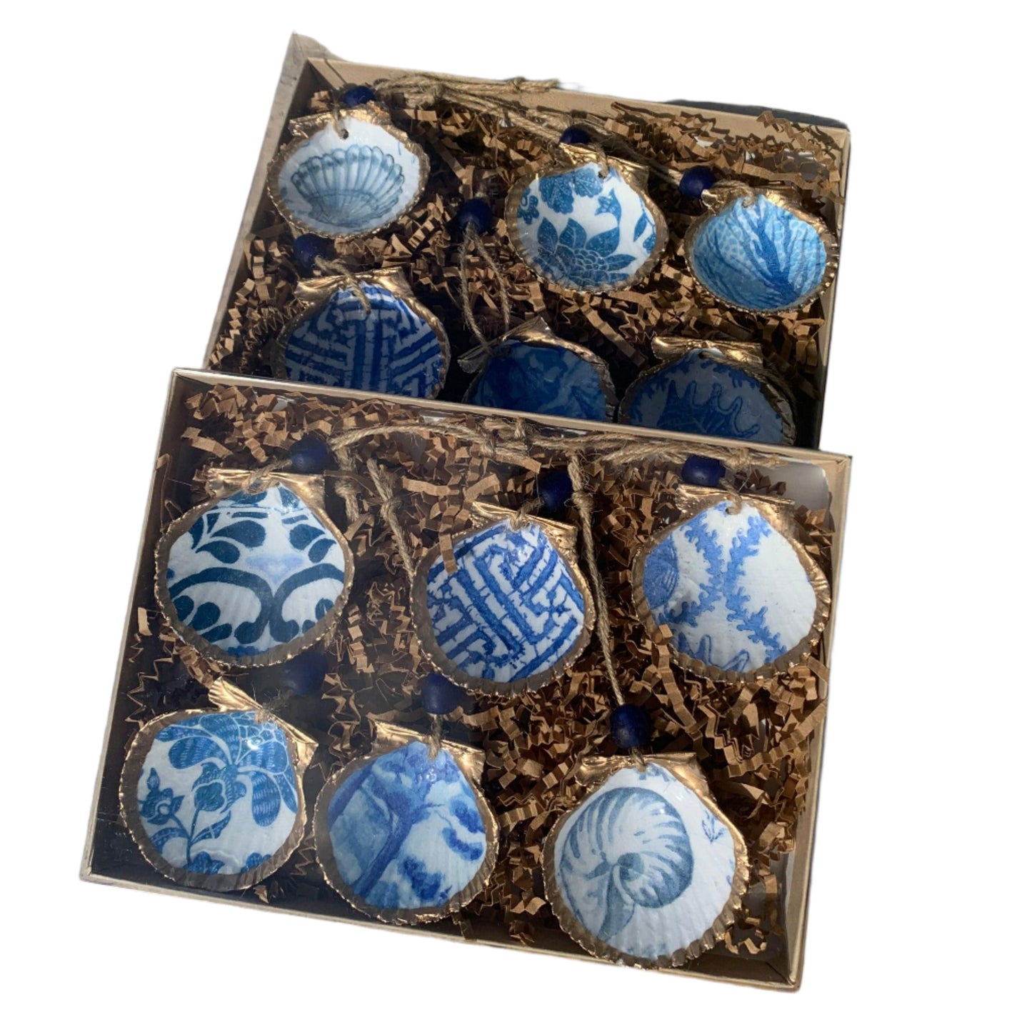 Twelve mini scallop shells painted blue and white in a box