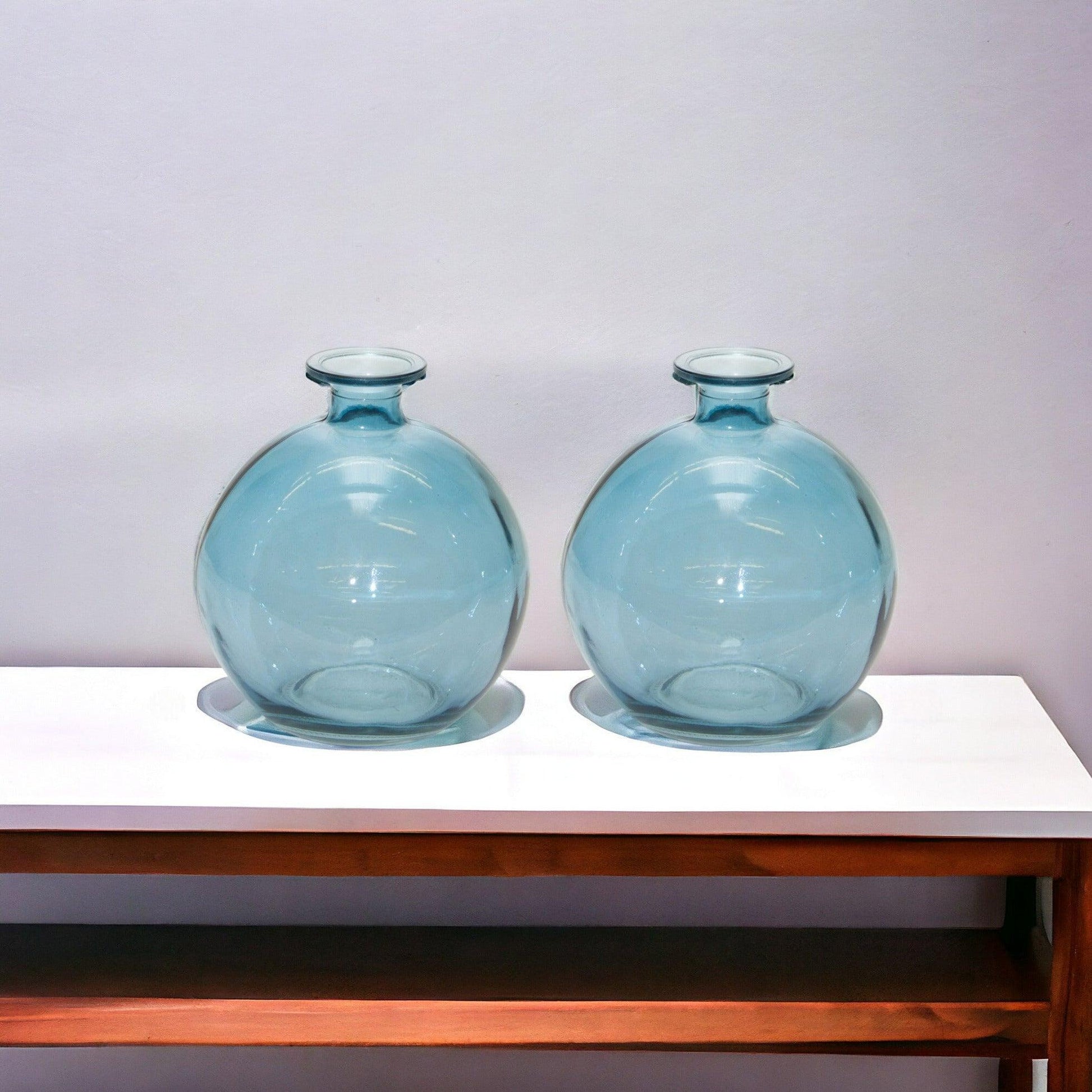 Two blue glass vases on a table