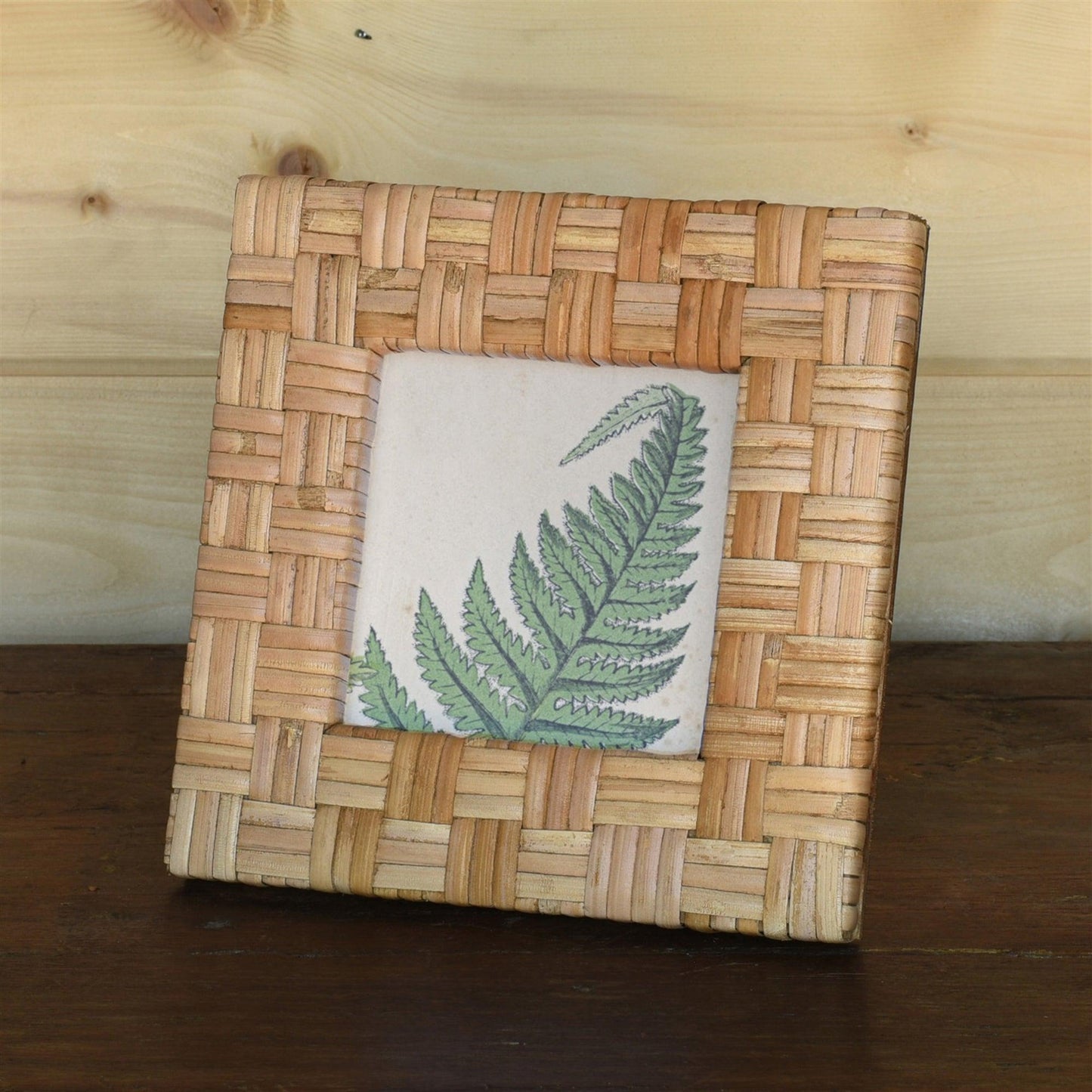 Square rattan picture frame in a wood table