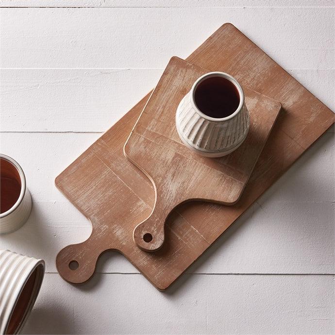 two wood cutting boards with a white cup