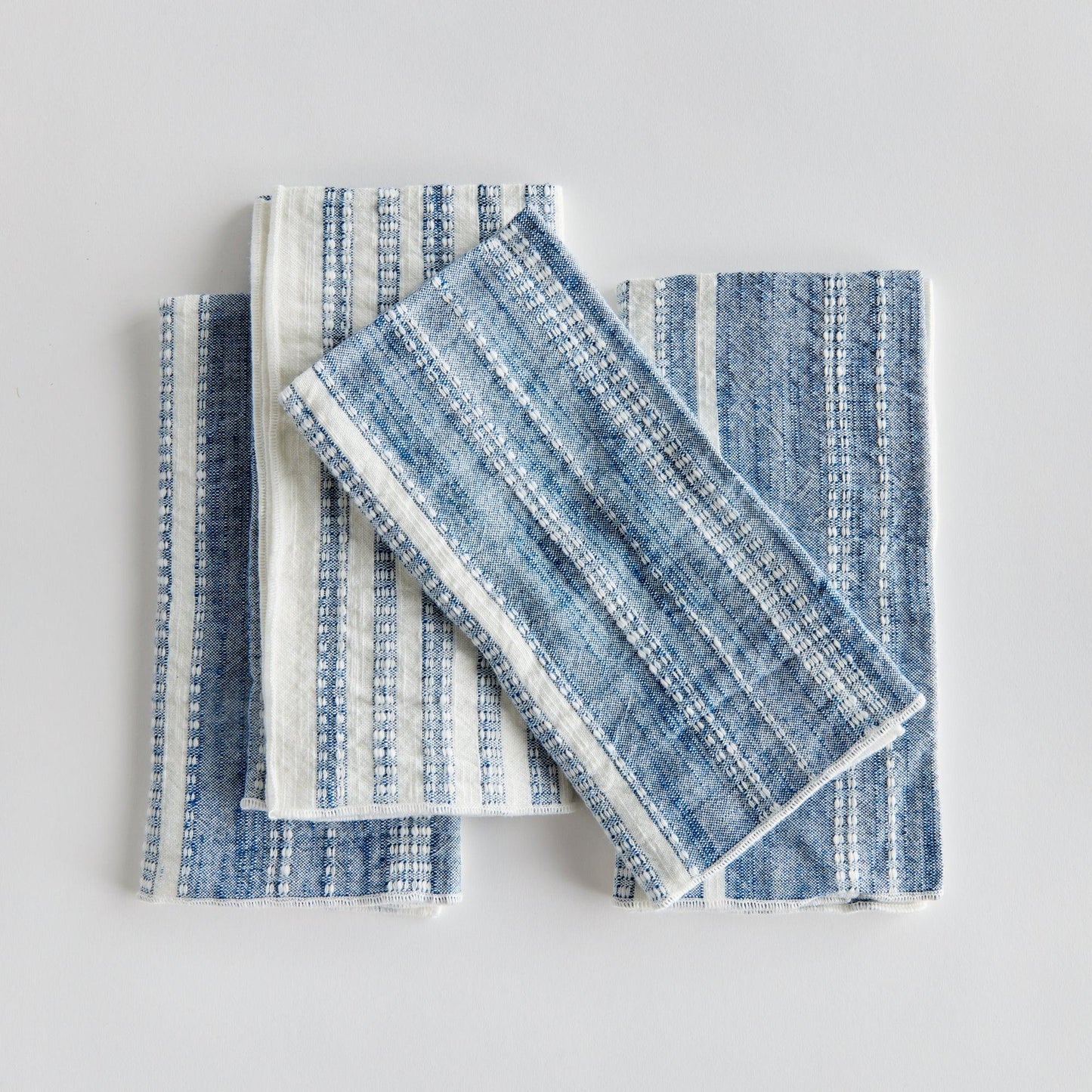 four blue and white dinner napkins