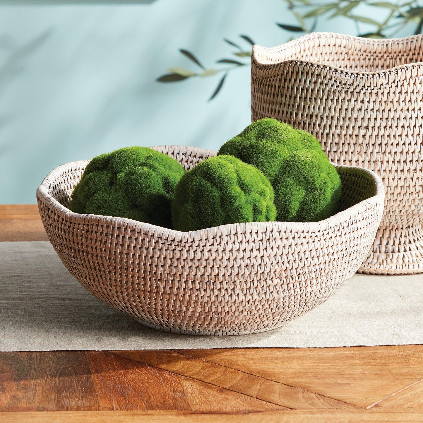Rattan bowl with green moss on a table
