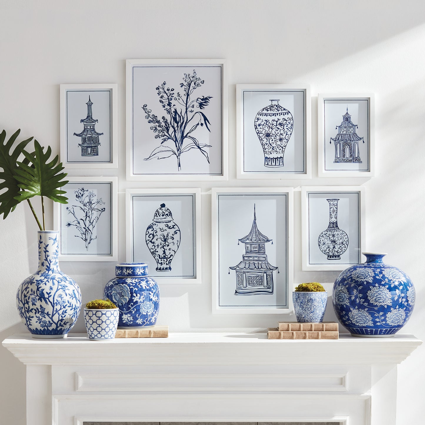 fireplace mantle with blue and white vases and blue and white art prints above it
