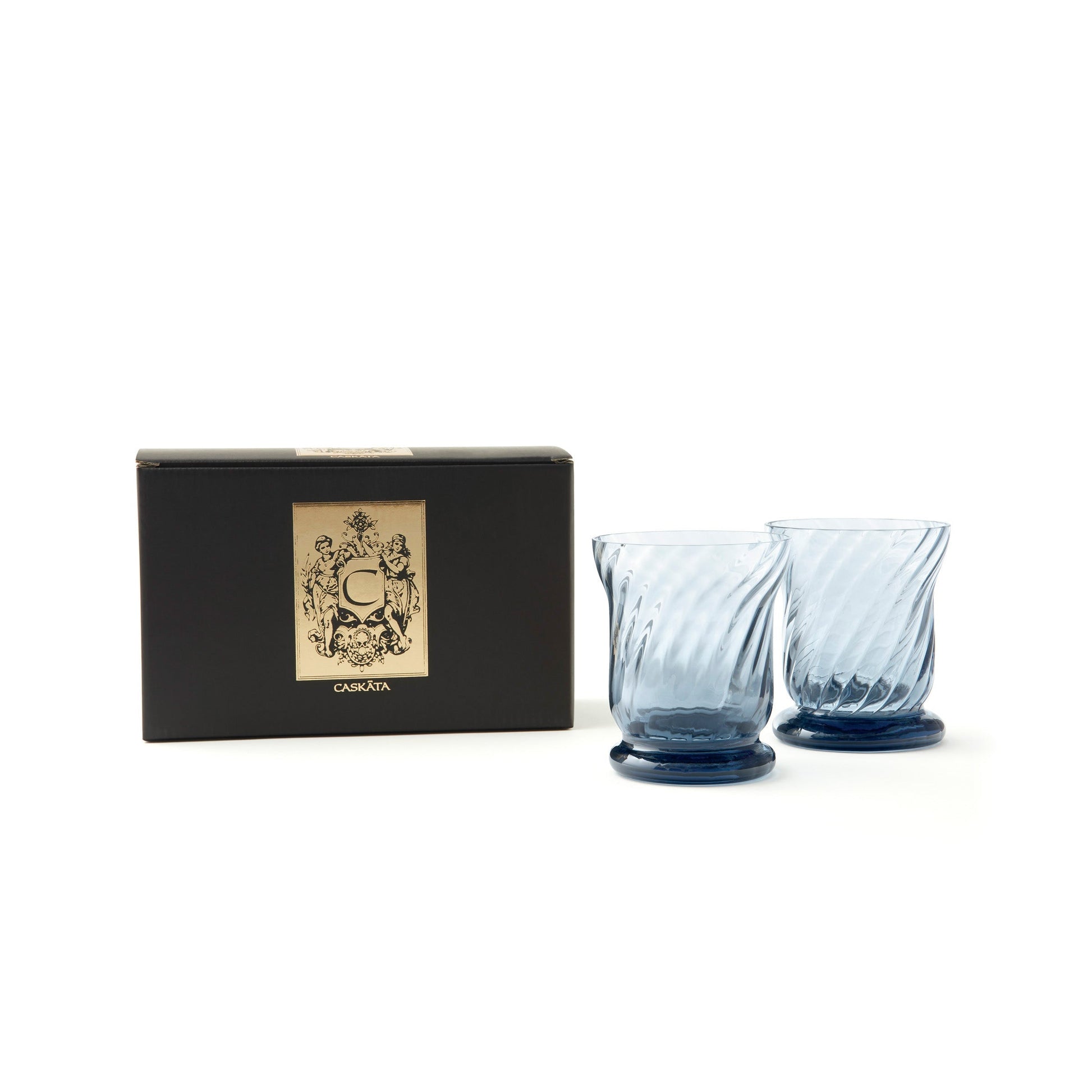 two blue glass votive candles holders next to a black box