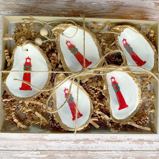gold and white shells with red christmas lighthouses painted on them