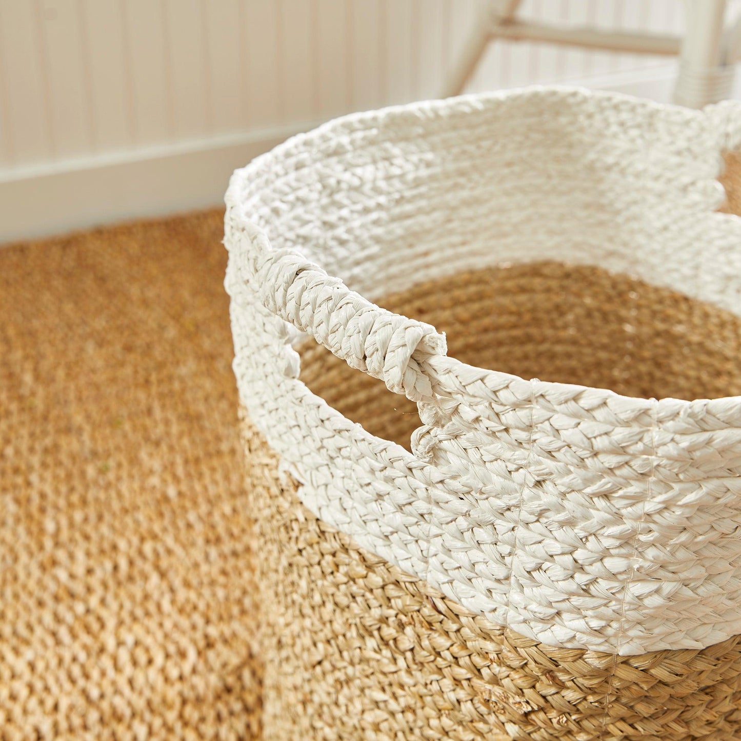 a white basket sitting on top of a wooden floor