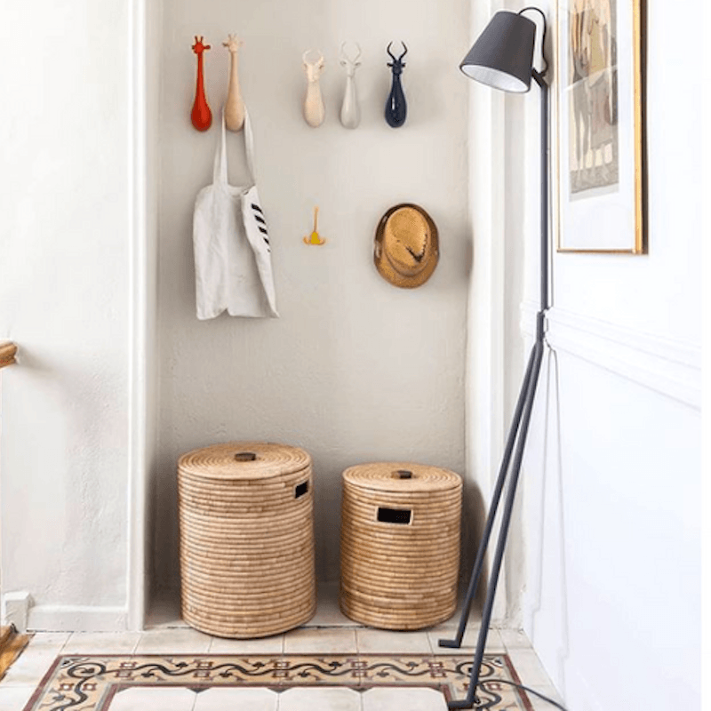 a hallway with two baskets and a coat rack