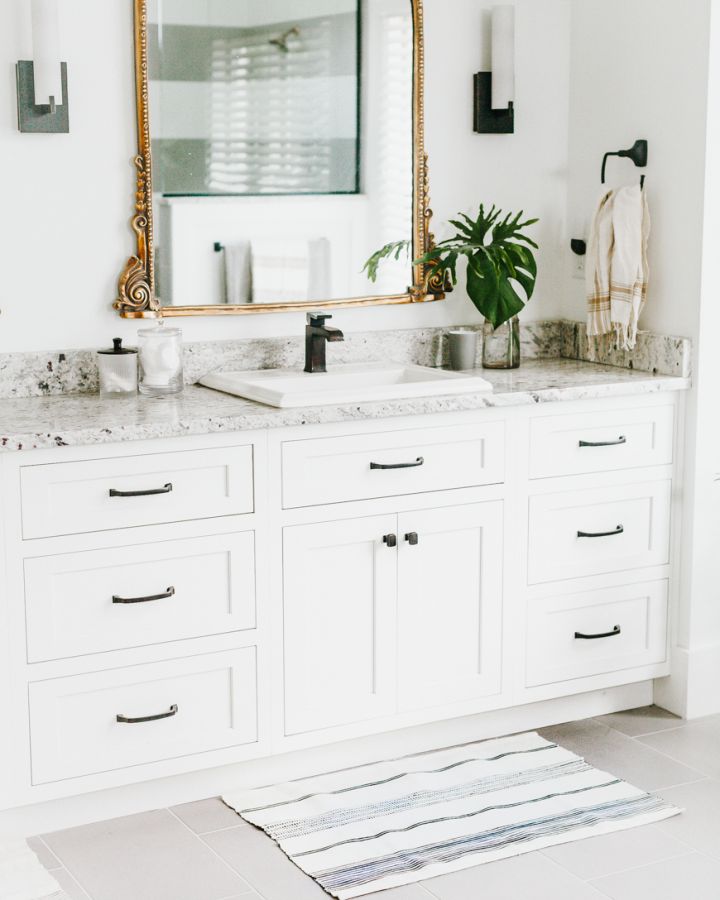 white and navy striped bath mat in front of white bathroom vanity