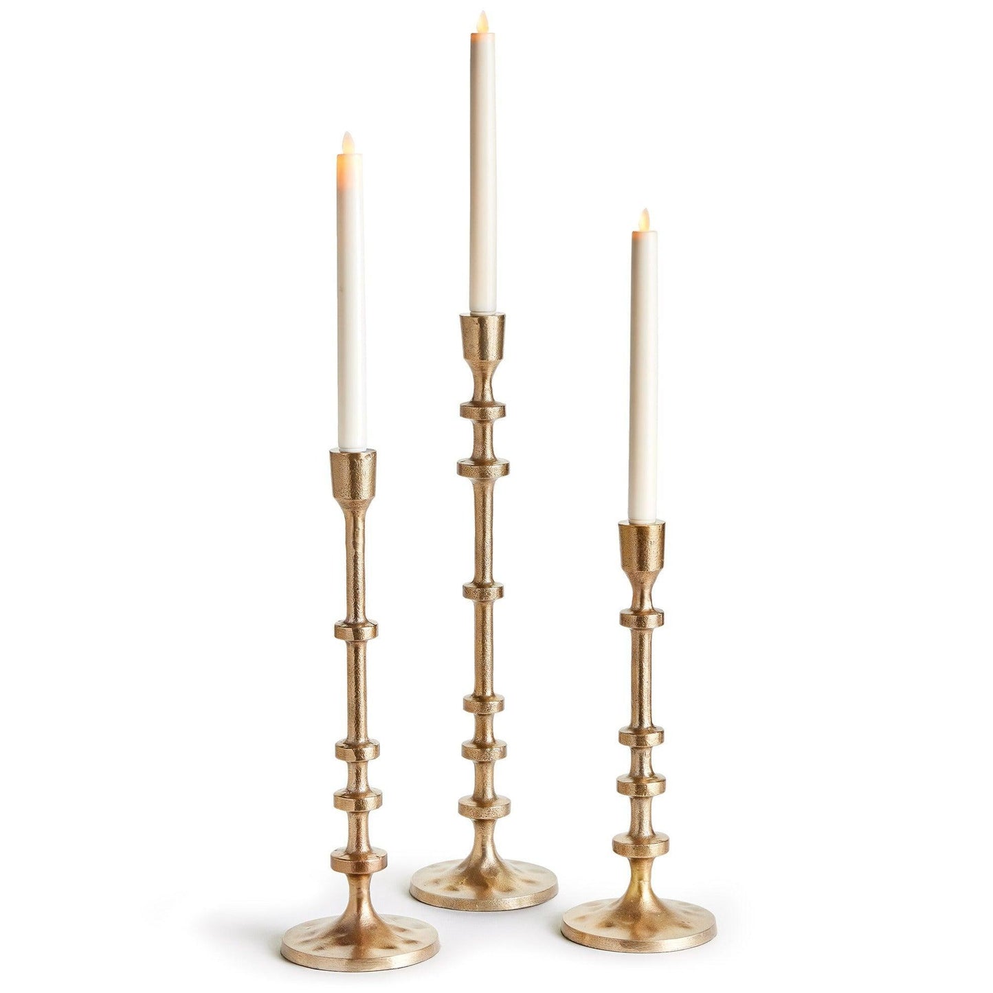 three gold taper candle holders with candles