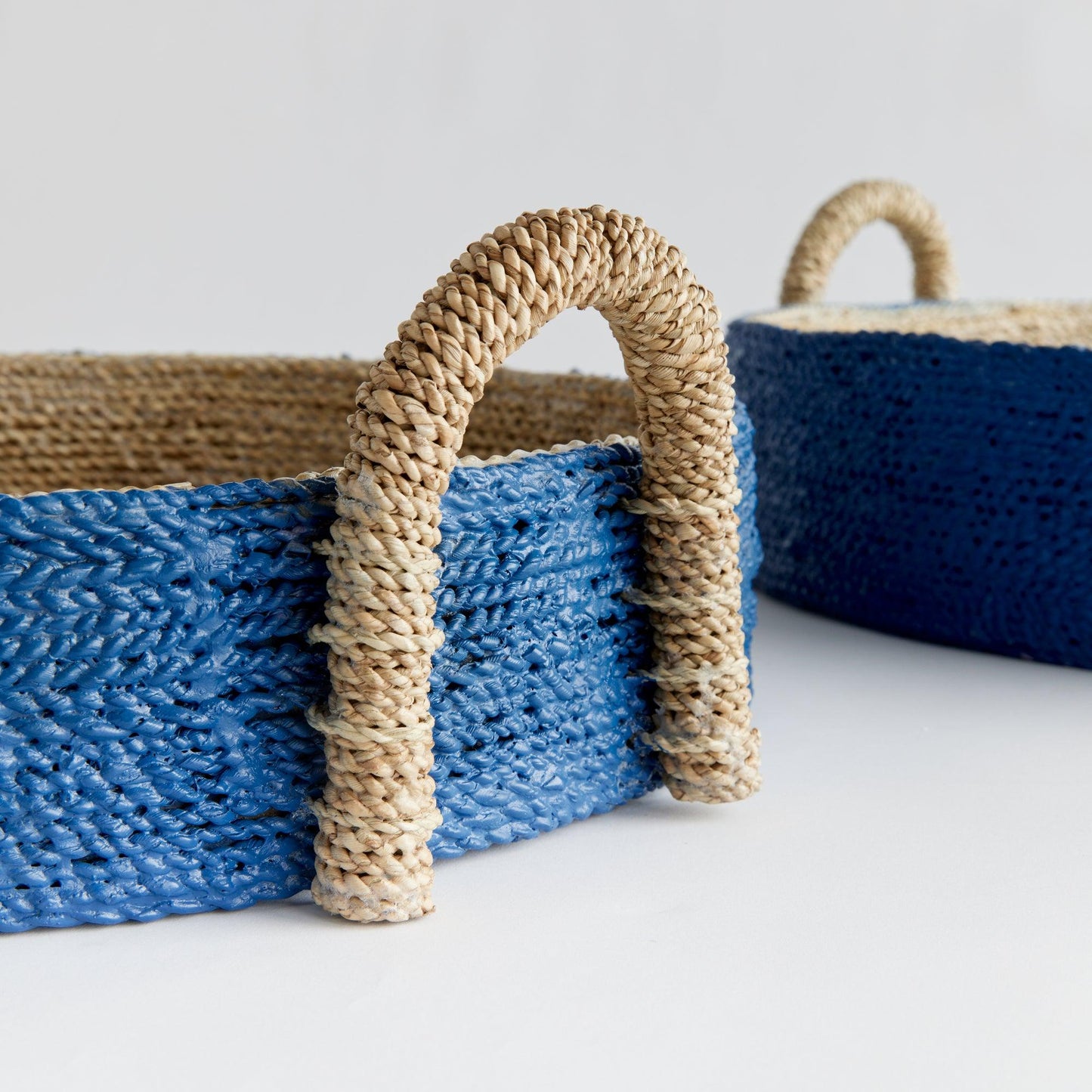a blue basket with a rope handle and a blue basket with a rope handle