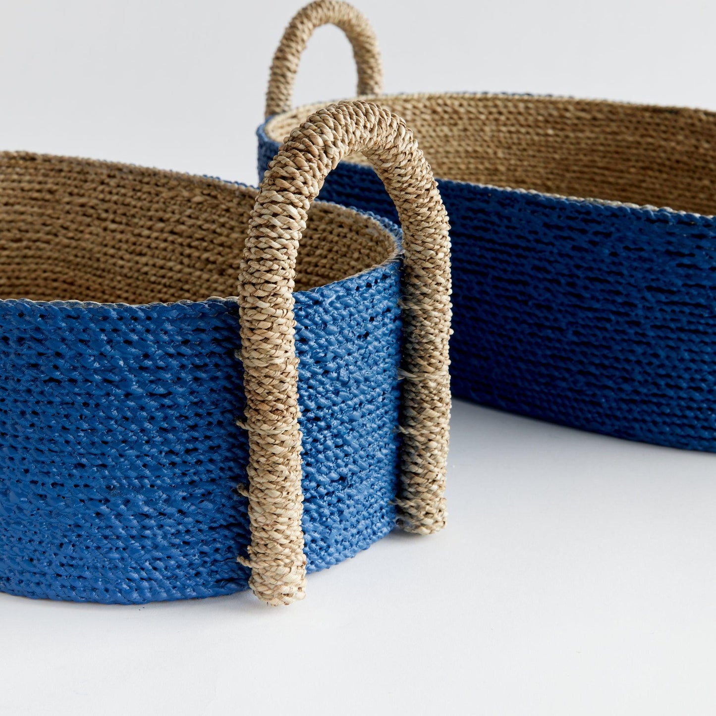 two blue baskets with handles on a white surface