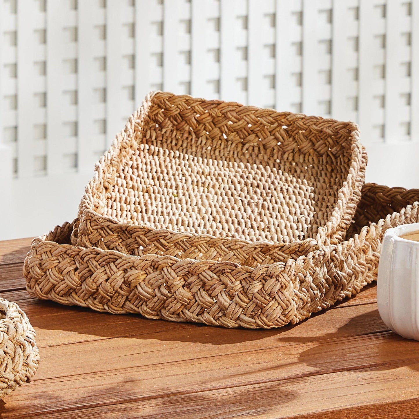 two braided trays on a wood table