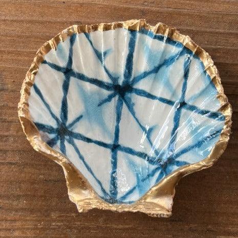 gold shell painted white with a blue design