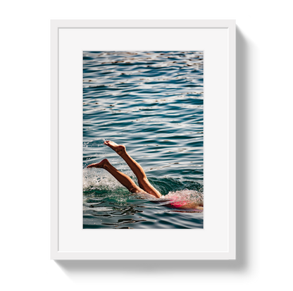 Joy Of Life swimmer photograph in a white frame with a white border, showing raised legs above blue-green water
