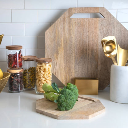 Leo mango wood boards in two sizes with cutout handles and a gold-colored stand, styled on a kitchen counter