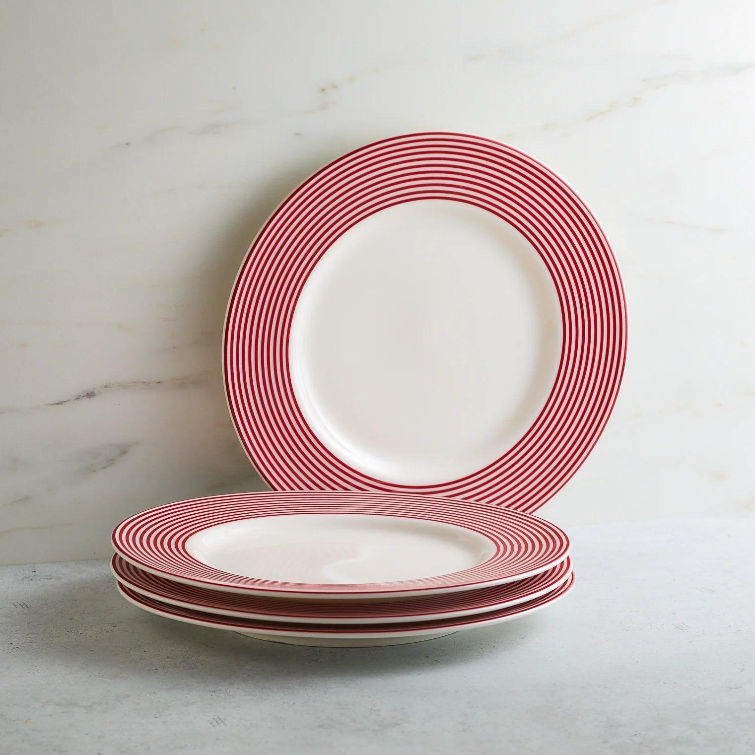 a stack of red and white plates sitting on top of a table