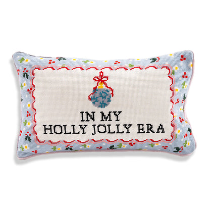 In My Holly Jolly Era needlepoint pillow with black lettering, a blue ornament, red scalloped detailing, and a colorful border