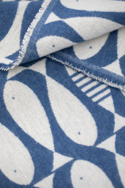 Close-up of the LUCA Sardines throw showing its navy and cream fish pattern and softly frayed edge