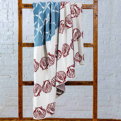 	Blue, red, and neutral Coastal Flag throw hanging from a wooden blanket ladder