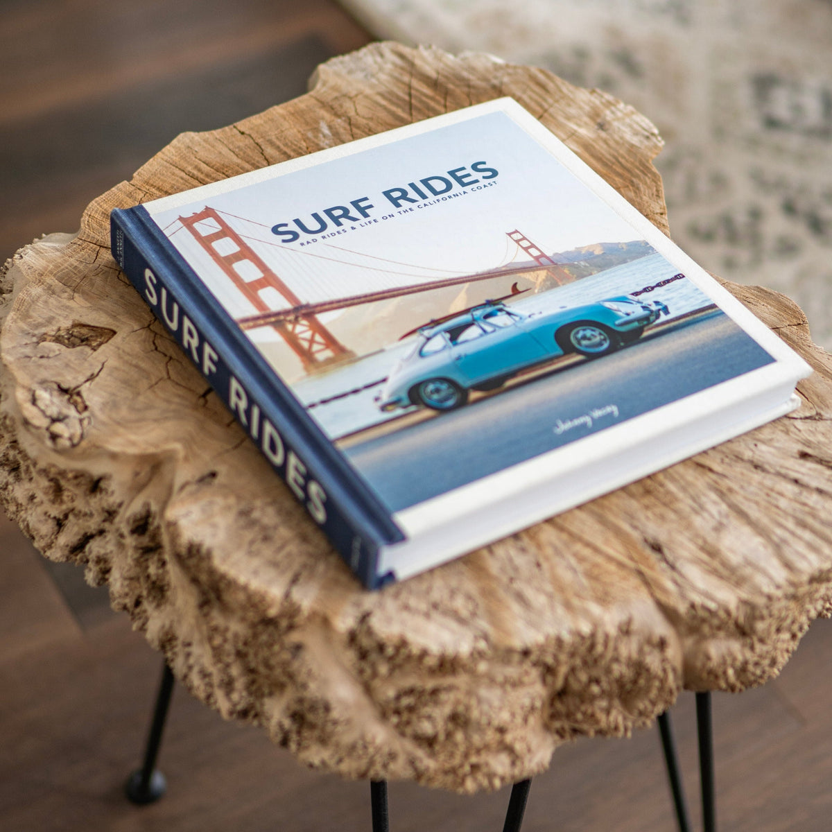 Surf Rides coffee table book displayed on a natural wood side table