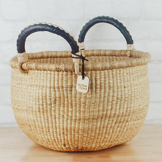 a woven basket with two handles and a tag on it