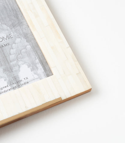 Close-up of the Mukhendu picture frame showing cream bone tiles and a gold-finish brass accent