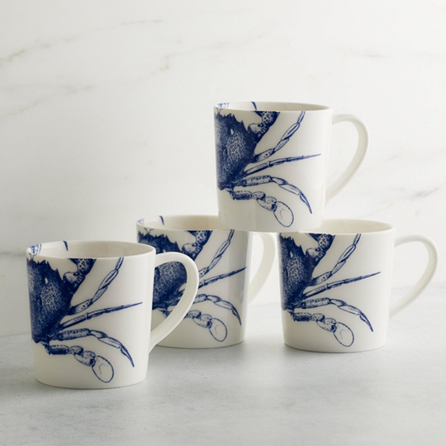 a set of four blue and white coffee mugs