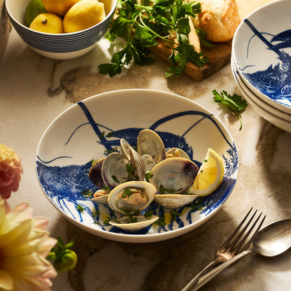 	Clams and lemon wedges served in a Blue Lobster Entrée Bowl on a kitchen counter