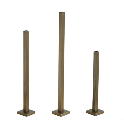 Set of three gold-finish iron taper candle holders with square stems and bases on a white background