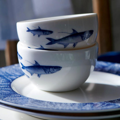 	Close-up of two stacked School of Fish porcelain snack bowls on a blue-bordered plate