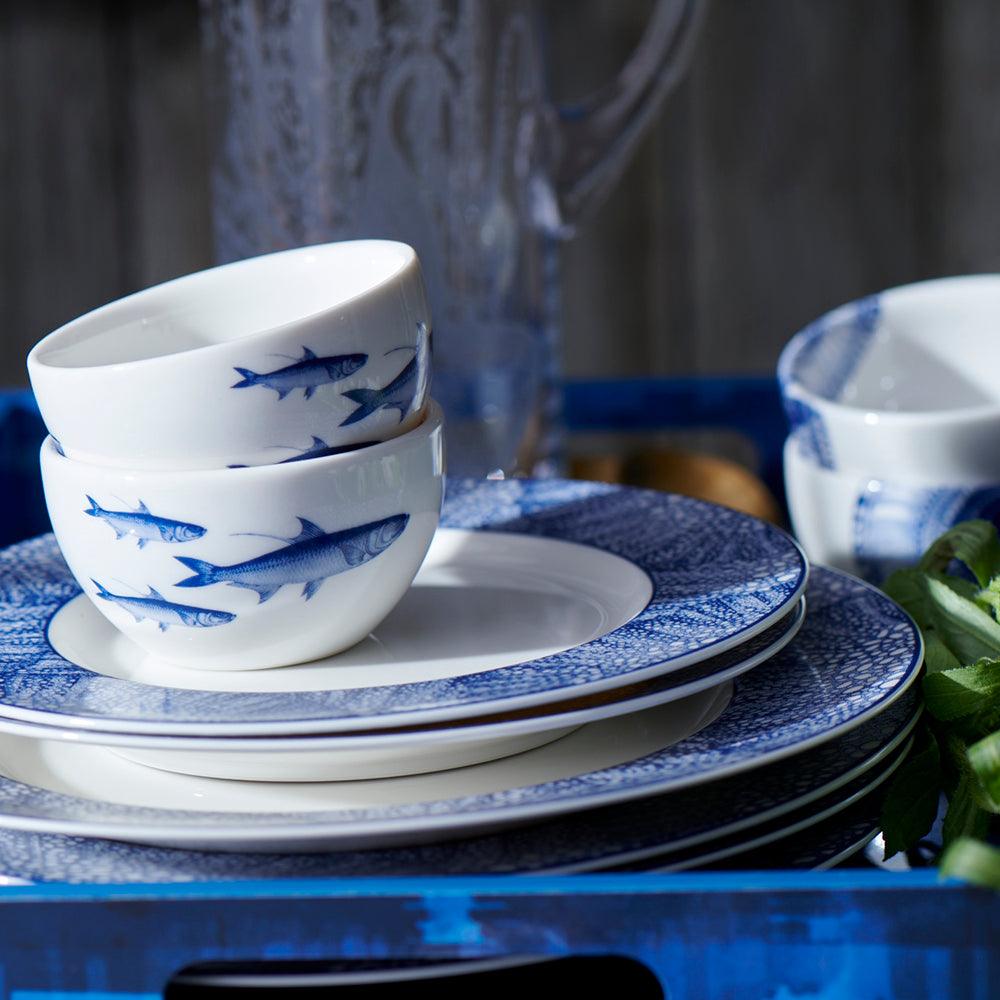 a stack of blue and white dishes on a table