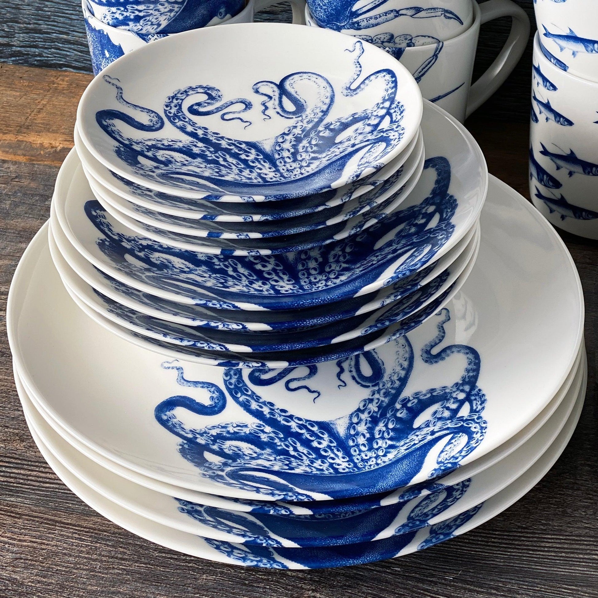 a stack of blue and white plates sitting on top of a wooden table