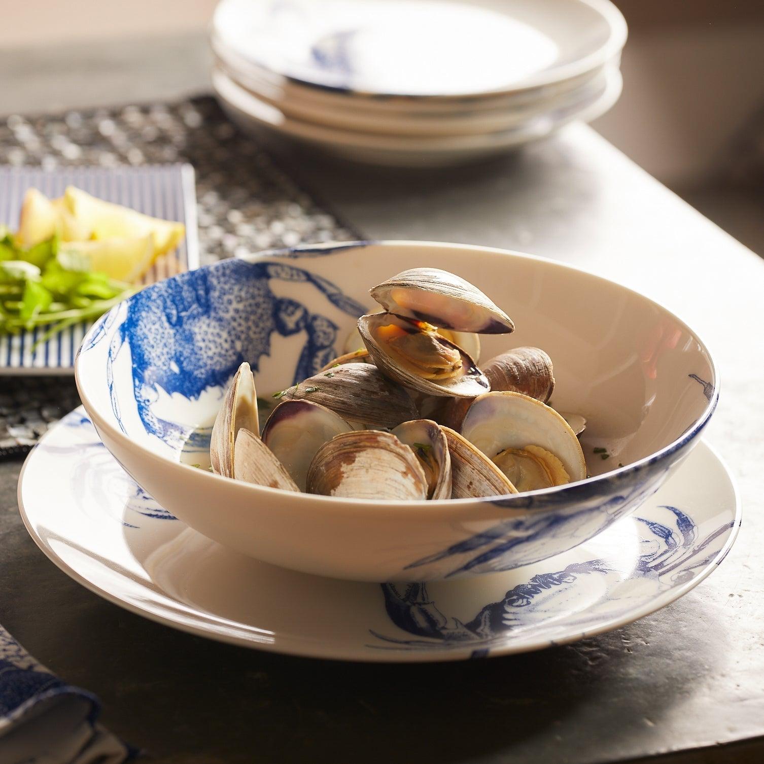 a bowl filled with clams sitting on top of a table