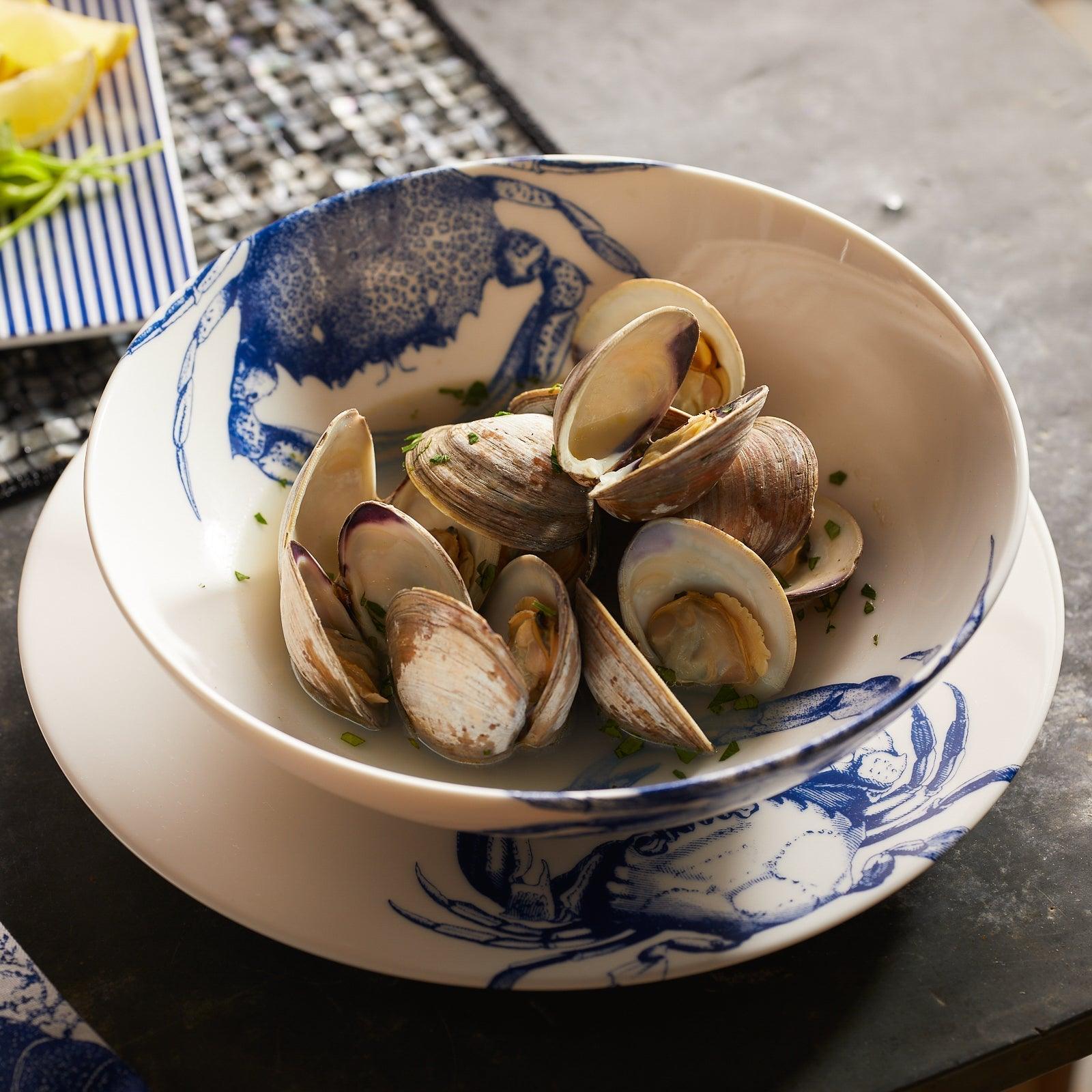 a bowl of clams sits on a table