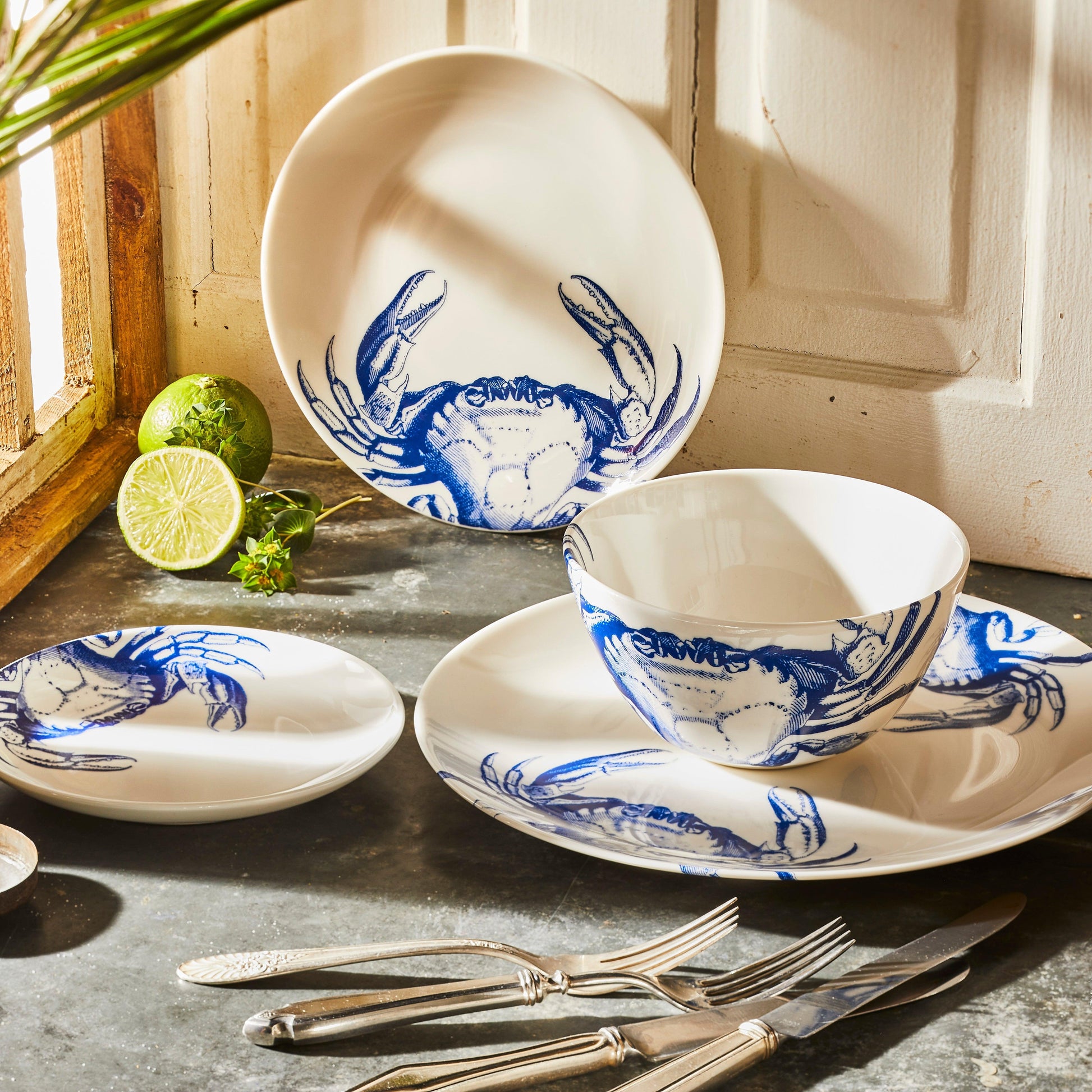 a table topped with blue and white plates and silverware