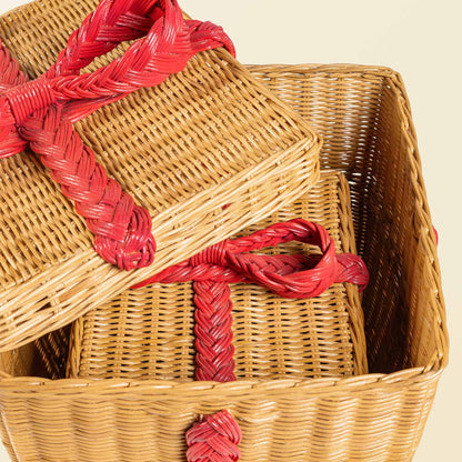 	Close-up of nested rattan storage gift boxes showing the weave, removable lids, and red bow details