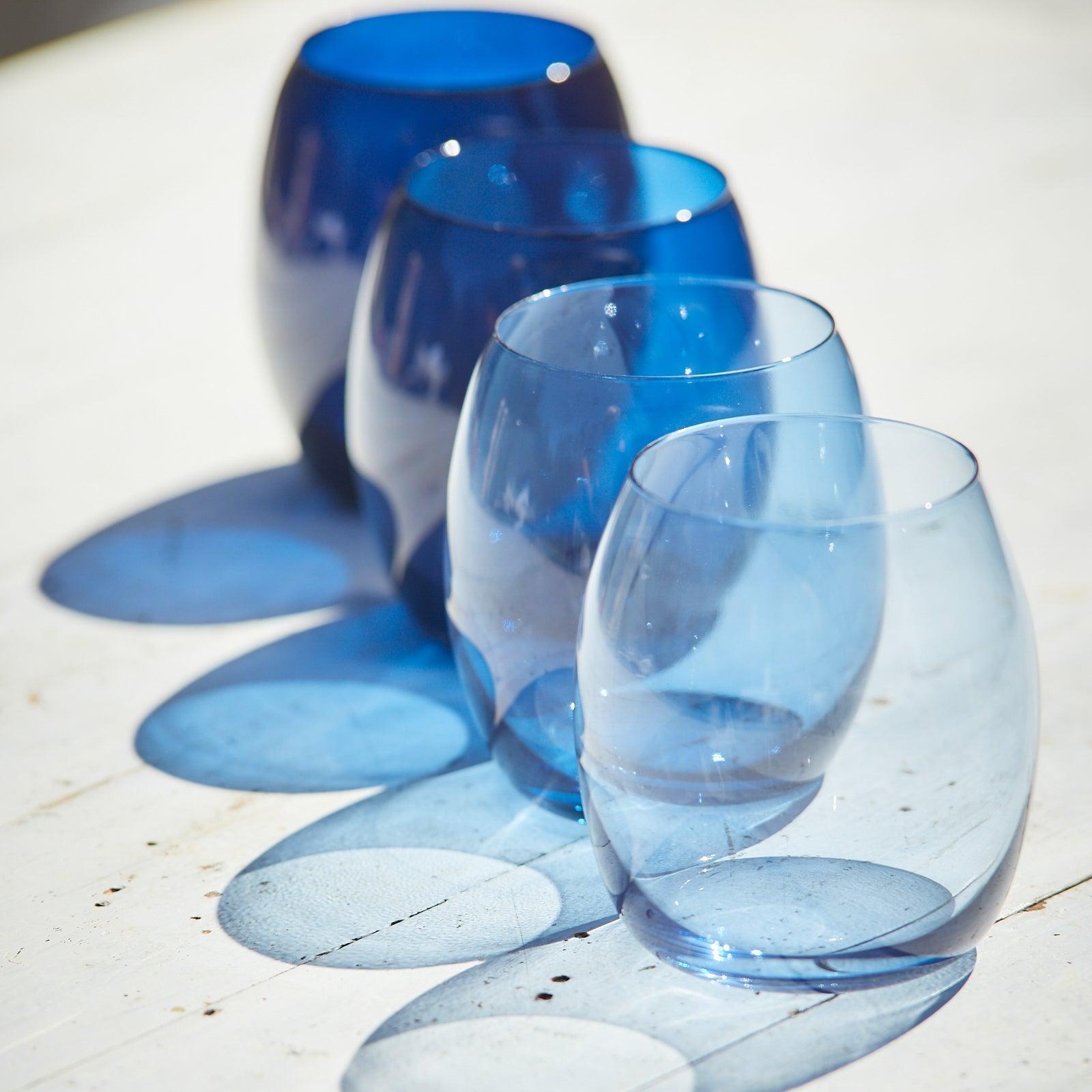 a group of blue wine glasses sitting on top of a table