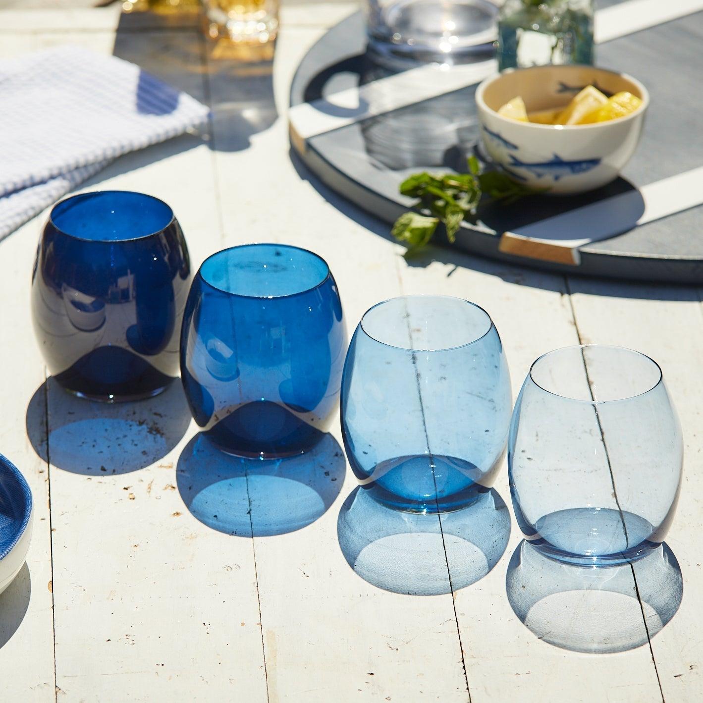 a group of blue glasses sitting on top of a wooden table