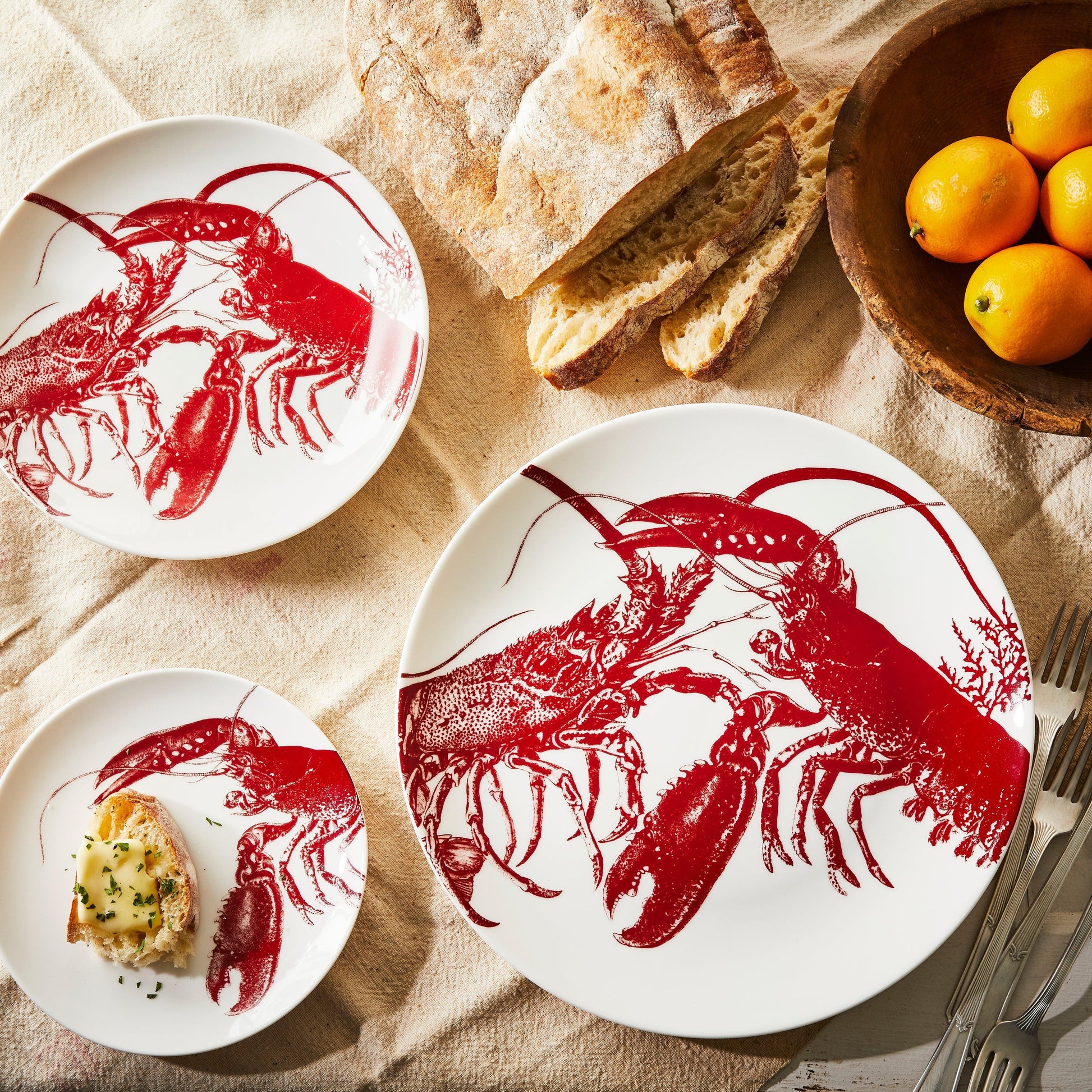 a table topped with plates of food and a bowl of oranges