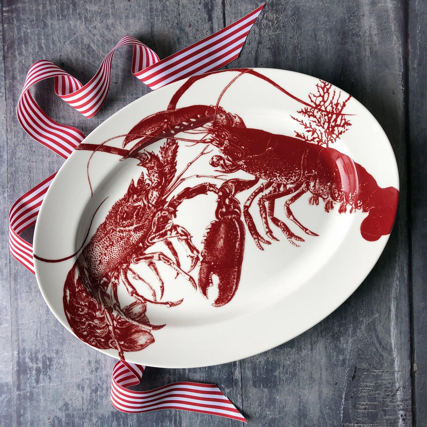 a white plate with a red lobster on it