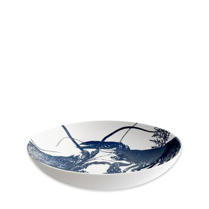 	Angled view of Caskata’s white porcelain entrée bowl featuring two detailed blue lobsters