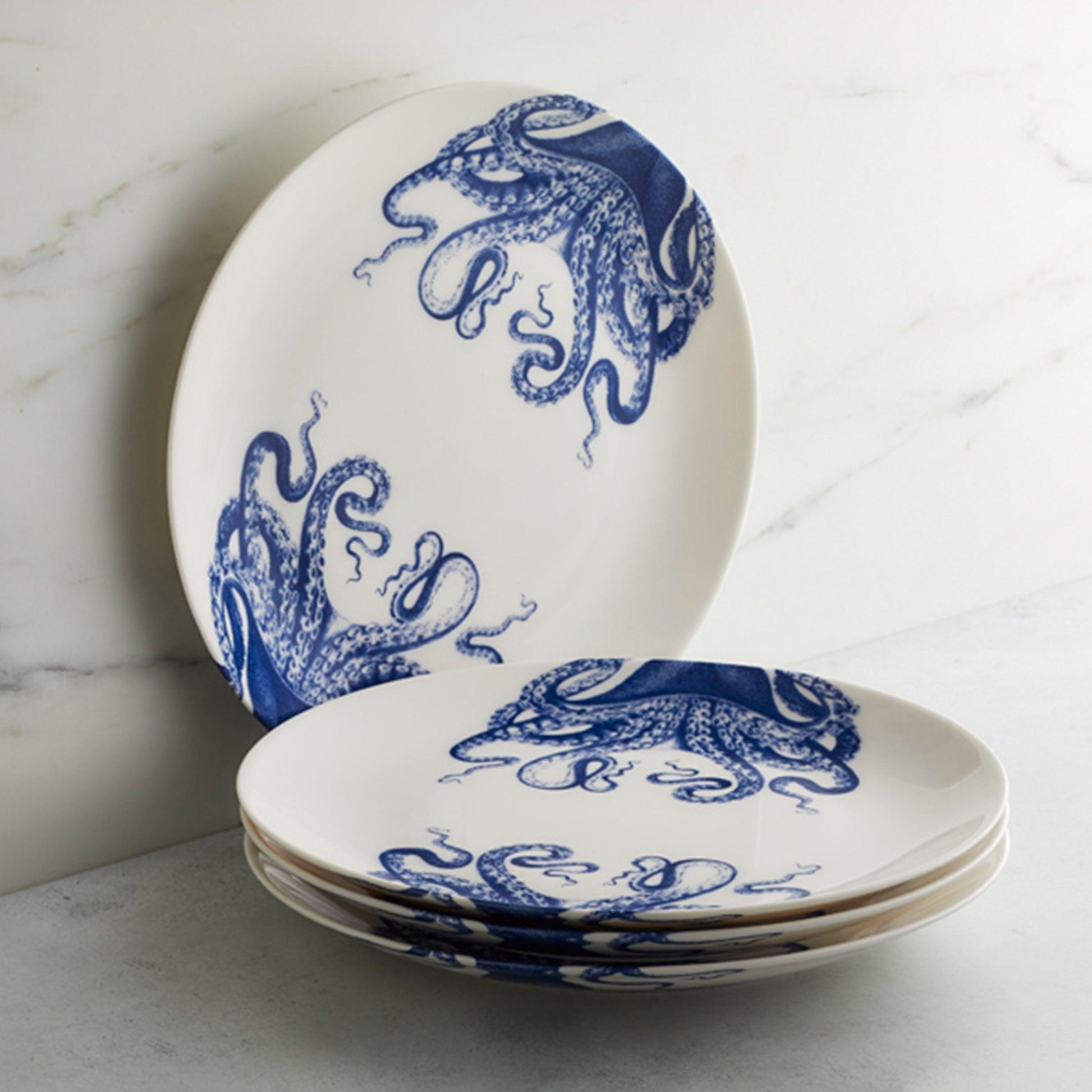 a set of four blue and white plates