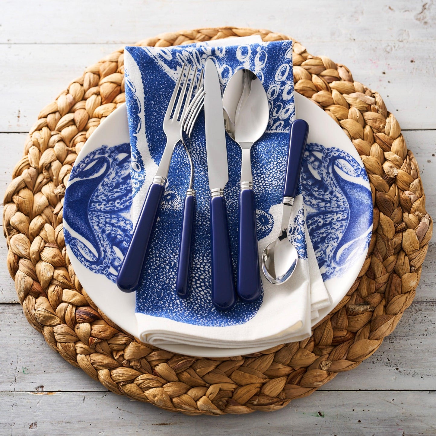 a blue and white plate topped with a fork and knife